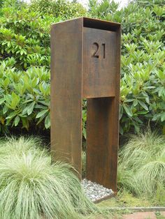 a large metal box sitting in the middle of a garden