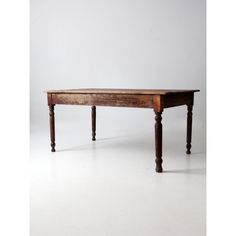 an old wooden table sitting on top of a white floor