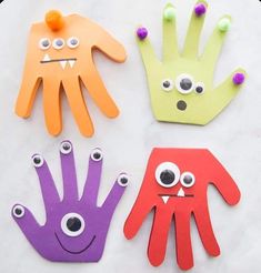 three paper hand puppets with googly eyes and hands painted to look like monster's