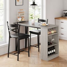 a kitchen table with two chairs next to it and bottles on the counter in front