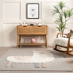 a living room with a rocking chair, rug and potted plant