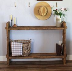 a wooden shelf with a hat on top of it next to a basket and flowers