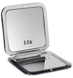 an empty compact mirror with the lid open on a white surface, showing the size