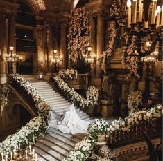 the bride is walking down the stairs in her wedding dress and bouquets on the steps