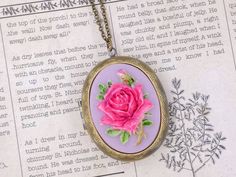 "This is a vintage inspired large rose cameo locket necklace. The beautiful pink fuschia rose with lavender purple background cameo is set on the lace pattern design locket. The cameo necklace is such a romantic classical accessory to keep in your treasure box. The locket can put photos and mementos. It has beautiful engraving designs on both the front and back. The locket size is 50mm x 38mm and the inner size for picture is 35mm x 26mm. It is suspended on a antique brass chain with a lobster c Vintage Rose-colored Jewelry For Gifts, Vintage Pink Oval Necklace, Vintage Pink Jewelry For Keepsake, Vintage Rose Necklace For Gift, Vintage Rose Design Necklaces In Rose Color, Vintage Rose Color Necklace For Gift, Vintage Rose Necklace For Wedding, Vintage Pink Necklace For Mother's Day, Vintage Rose Design Necklace For Gift