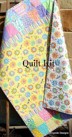 two quilts are laying on top of each other in front of a wooden chair