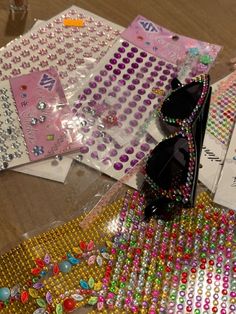 there are many stickers and beads on the table