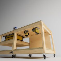 a workbench made out of wood with tools on the top and wheels attached to it