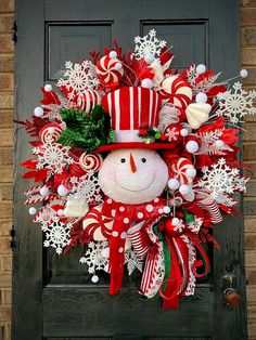 a wreath with a snowman and candy canes on it is hanging on the front door