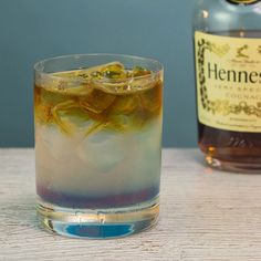 a glass filled with ice next to a bottle