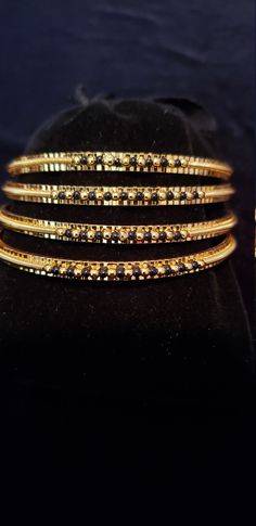 "* Handcrafted Gold Plated 4 Bangle Set. Sold as a set. * Bangles with pretty black beads and gold beads * High Quality 22 K Gold Plated- 4 Bangle set * Size 2.6 has 2.40\" inner circle diameter; Size 2.8 has 2.52\" inner circle diameter Gorgeous gold-plated bangle/ bracelet best exemplifies the careful craftsmanship done on it -- a specialty at Nemali Jewelry. It has a special tone of elegance attached to it. The intricate handmade design of the bangle/bracelet set gives it a fresh and original Traditional Black Bracelets For Party, Traditional Black Party Bracelets, Gold Beaded Bangle Jewelry, Black Bangle For Wedding, Gold Bangle With Round Beads For Party, Black Bangle Bracelets For Festive Occasions, Festive Black Bangle Bracelets, Gold Party Bangle With Round Beads, Festive Black Bangle Bracelet