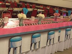 a long table with chairs and vases on it