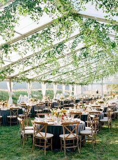 an outdoor tent with tables and chairs set up for a wedding reception under the canopy