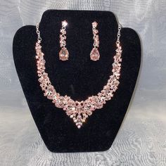 This Necklace Set Features A Silver Tone With Pink Sparkling Jewels. Comes With Necklace And Matching Earrings. Evening Rose Gold Jewelry With Sparkling Stones, Sparkling Rose Gold Jewelry For Evening, Sparkling Rose Gold Evening Jewelry, Teardrop Jewelry With Sparkling Stones For Evening, Silver Metal Jewelry Sets For Evening, Silver Crystal Jewelry With Matching Earrings, Elegant Sterling Silver Rhinestone Necklace For Party, Party Jewelry In Rose Gold With Sparkling Stones, Sparkling Teardrop Jewelry For Evening