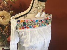 This beautiful hand embroidered Mexican blouse is comfortable, fresh and stylish With beautiful flower embroidered detailed work on the top Get the Boho style you like Perfect to wear with your favorite jeans You will love your unique one of a kind piece Is a MUST HAVE in you wardrobe Every blouse is individually handcrafted Color may vary on stitching as each blouse is unique Perfect for any occasion Perfect gift idea *accesories sold separately* **HAND WASH ONLY** Follow us on Instagram @ mard Folk Style Blouse With Tonal Embroidery For Spring, Casual Embroidered Top With Intricate Embroidery For Spring, Traditional Floral Embroidered Top For Spring, Traditional Tonal Embroidered Top For Spring, Spring Folk Embroidered Top With Floral Embroidery, Spring Traditional Embroidered Fitted Top, Fitted Traditional Embroidered Top For Spring, Multicolor Embroidered Top With Embroidered Hem For Spring, Traditional Spring Embroidered Top With Embroidered Hem