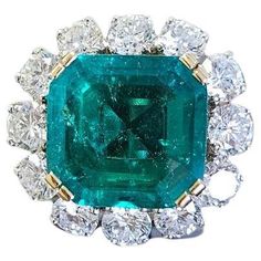 This exquisite investment-grade ring features a stunning 6.78-carat emerald, certified by SSEF and verified to be completely untreated (NO OIL), highlighting its exceptional natural beauty. The vibrant green emerald is set in a luxurious 18K white gold band, exuding elegance and sophistication. Encircling the magnificent emerald are 12 dazzling round-cut white diamonds, meticulously placed to enhance the brilliance and allure of the central gemstone. The harmonious blend of the lush green emeral Marquis Ring, Columbian Emeralds, Green Emerald Ring, Emerald Diamond Ring, Gold Cocktail, Colombian Emeralds, Diamond Cocktail Rings, Diamond Flower, Platinum Ring