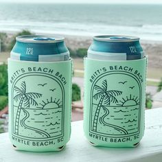 two can coolers sitting next to each other on a window sill near the beach