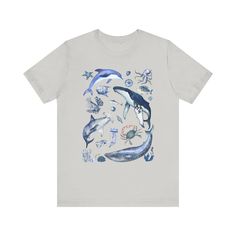 a white t - shirt with dolphins and sea creatures on the front, in watercolor