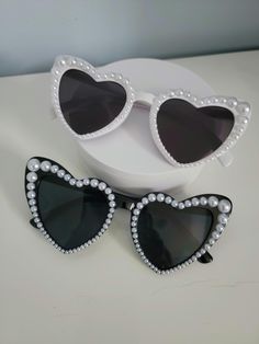 Get ready to turn heads and add some glamour to your look with these fabulous heart-shaped sunglasses with white pearl bling! These statement sunglasses are perfect for weddings, bridal accessories, sunny days, festivals or just adding a touch of glam to your outfit. The pretty pearls embellishing the frames add a touch of elegance and sophistication, making these shades a must-have accessory for any fashion-forward individual. Stand out from the crowd and sparkle in the sun with these stunning Statement Sunglasses, Shaped Sunglasses, Heart Shaped Sunglasses, The Pretty, White Pearl, Bridal Accessories, Eyewear Sunglasses, Pearl White, Fashion Statement