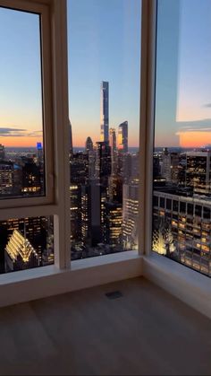 an empty room with large windows overlooking the city