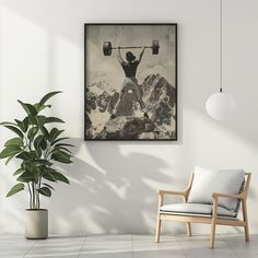 a black and white photo of a man doing exercises with barbells in the mountains