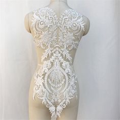 a mannequin with white lace on it's body and back, standing in front of a white background