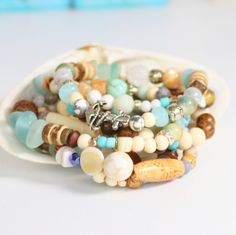 "Woman's Beachy Boho Anchor Bracelet, Fun Surf & Sea Eclectic Bracelet! Tropical Boho Maritime Stack ANCHOR BRACELET, ♥Beautiful Summer Themed Bracelets for stacking, I use a variety of materials you would find strolling along a warm sandy beach, so to capture this feeling I used Sea Glass, Shell, Gemstones, Jade, White Wood, Ceramic, and Silver Spacers, Jewelers Stretch Cord. The maritime symbol of the anchor represents truth, stability and hope. Let the truth guide you as you navigate the Bohemian Stretch Bracelet For Vacation, Bohemian Jewelry With Letter Beads For Beach Season, Hand Wrapped Multicolor Beach Beads, Bohemian Adjustable Stretch Bracelet For Beach Season, Adjustable Bohemian Bracelet For Beach Season, Bohemian Strand Bracelets For Beach Party, Bohemian Beach Jewelry With Letter Beads, Bohemian Beaded Bracelets For Beach Season, Bohemian Round Beads Bracelets For Beach Season