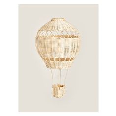 a white hot air balloon sitting on top of a wall next to a basket bag