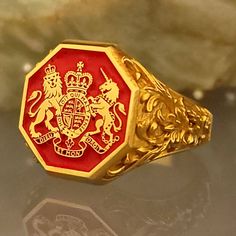 a close up of a gold ring with a red and white crest on the front