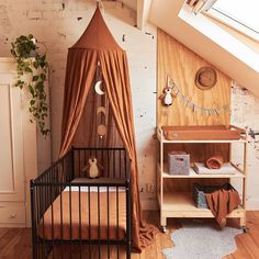 a baby's room with a canopy bed and wooden flooring