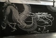 a black and white dragon painted on the side of a building