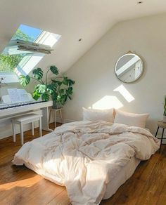 a bed sitting under a window next to a white piano