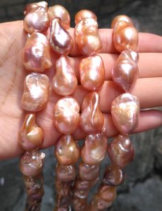 several different types of pearls being held in someone's hand