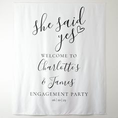 a welcome sign hanging from the side of a white wall with black lettering that says, she said yes welcome to charlotte & james engagement party