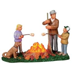 three figurines are standing around a campfire with two boys and a dog