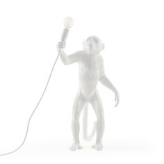 a white monkey holding a light bulb in it's right hand and standing on its hind legs