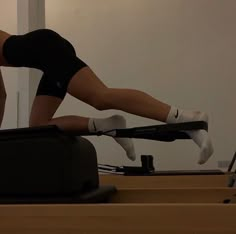 a woman is doing an exercise on a treadmill with her feet in the air