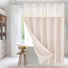 a bath room with a shower curtain and a rug on the floor in front of it