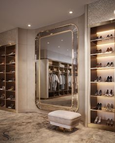 a large mirror sitting in the middle of a walk - in closet next to a white bench