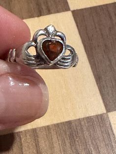 This is  a beautiful Vintage 925 sterling silver  and garnet Claddagh  Ring  Beautiful Sentimental Love Token ring is stamped 925  with a hallmark  and is approximately a size 6 . It is enhanced with a lovely Garnet middle of the heart. This ring is in good condition. The shank is not bent but is not perfectly round as a NEW ring would be remember this is a vintage ring. This would make a beautiful Gift :) any questions please ask, Please read shop policies before purchasing, and review pics as they are part of my description Thank you for looking more photos upon request Irish Ring Claddagh, Claddagh Rings, Love Token, Rings Statement, Vintage Rings, Garnet, Statement Rings, Jewelry Rings, 925 Sterling Silver