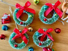 three christmas wreath ornaments on a wooden table