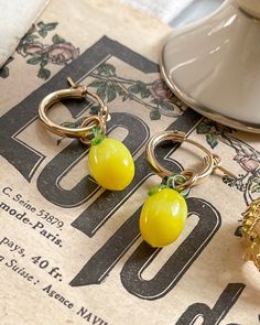 Add the perfect amount of zest to your wardrobe with these Limón Hoops! These lemon hoop earrings are perfect for any summer day, so you can show off your sunny side, no matter the weather! Beat the heat in style and have everyone asking, “Where'd you get those?” (Hint: Here!) The cutes little glass lemons 18mmx7mm on a gold filled hoop 15mm. Trendy Single Hoop Earring For Summer, Handmade Neon Yellow Jewelry For Summer, Summer Gift Jewelry In Neon Yellow, Summer Small Hoop Single Earring, Neon Yellow Jewelry For Summer Gift, Single Small Hoop Earring For Summer, Yellow Small Hoop Earrings For Summer, Yellow Hoop Earrings For Summer, Yellow Hoop Earrings For Spring