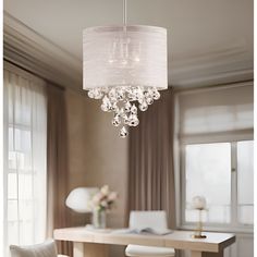 a chandelier hanging from the ceiling in a dining room with chairs and table