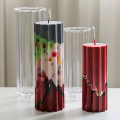 two red candles sitting next to each other on a table