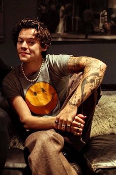 a man with tattoos sitting on a couch