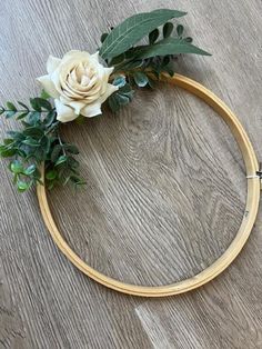 a wooden hoop with flowers and greenery on it