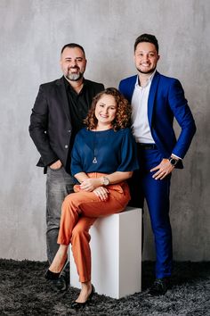 two men and a woman posing for a photo