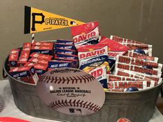 a metal bucket filled with candy and baseballs