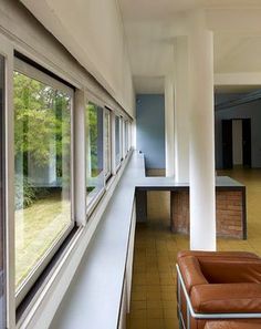 an empty room with many windows and chairs