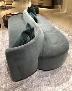 a large grey couch sitting on top of a carpet covered floor